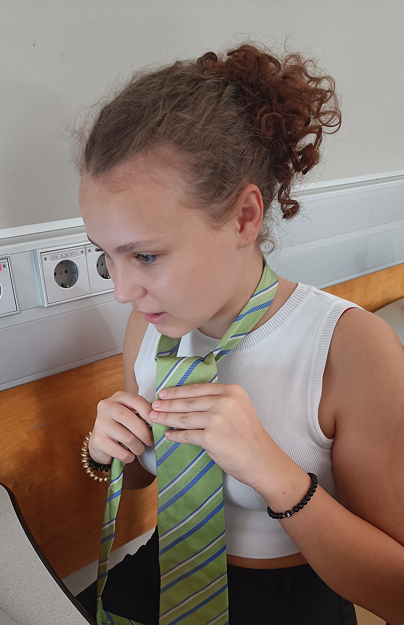 Schüler:innen beim Krawatte binden